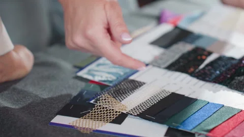 Close up of hand selecting colorful net and lace material samples for fashion Stock Footage 307135900
