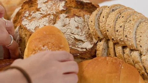 Close Up of Hand Selecting Fresh Bread from Bakery Assortment Stock Footage 337746925