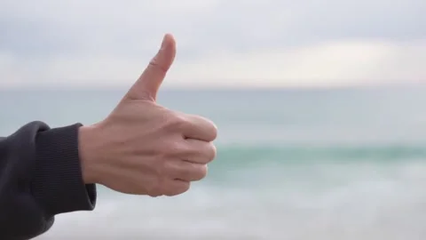A close-up of the hand showing the sign is cool and not cool Stock Footage 236534571
