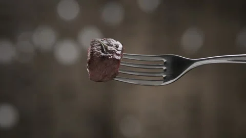 Close-up hand shows fork with delicious grilled slice of meat Stock Footage 143091773