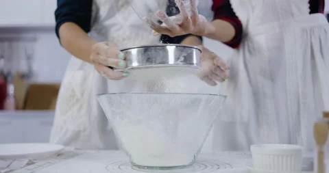 Close-up of hand sift flour with sifter. Bakery in kitchen at home. Stock-Footage 157048547