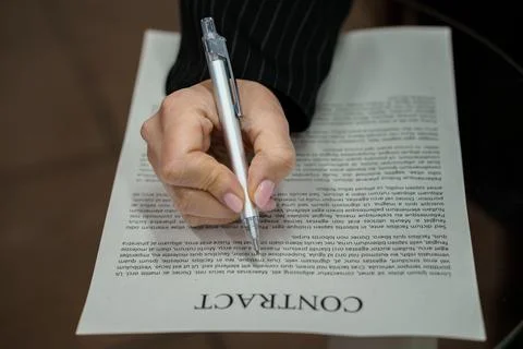 A Close-Up of a Hand Signing a Contract on a Table Stock Photos