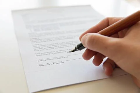 Close up of hand signing document. Stock Photos
