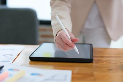 Close-up of hand signing electronic documents on a tablet with a digital pe.. Stock Photos