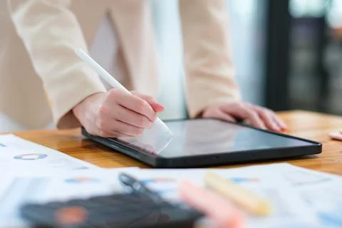Close-up of hand signing electronic documents on a tablet with a digital pe.. Stock Photos