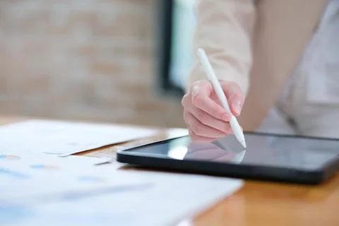 Close-up of hand signing electronic documents on a tablet with a digital pe.. 스톡 사진