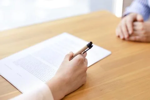 A close-up hand signs a document with a pen, a lease agreement, a contract. Stock Photos