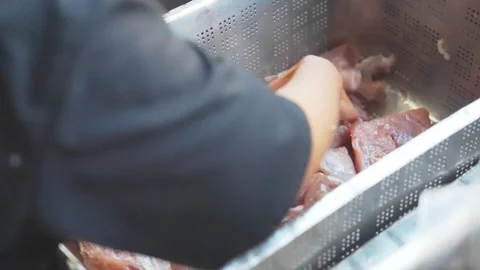 Close-Up of Hand Sorting Raw Meat in Perforated Metal Crate at Butchery Stock Footage 346653998