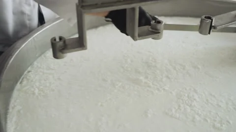 Close-up of a hand with a spatula for stirring cheese. Cheese making technology. Vídeo Stock 177589966