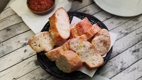 Close-up of a hand spreading tomato puree with olive oil on a baguette Stock Footage 321949594
