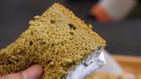 Close-up of Hand Spreading White Cream on a Slice of Sponge Cake Stock Footage 331776464