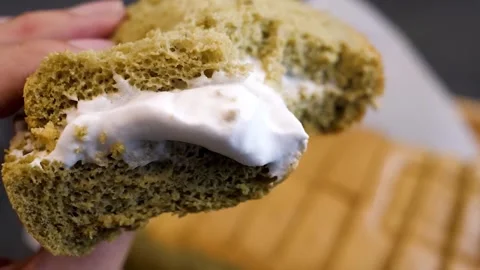 Close-up of Hand Spreading White Cream on a Slice of Sponge Cake Stock Footage 331776476