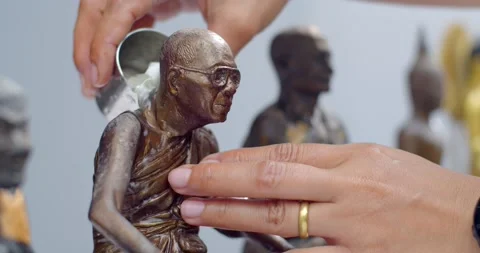 Close up hand sprinkle water onto a Buddha Statue in Songkran festival Thailand. Stock Footage 238891915