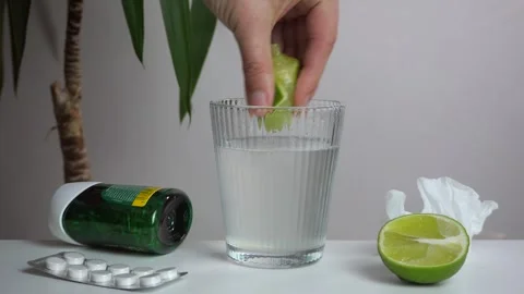 Close-up of a hand squeezing lime juice into a glass Stock Footage 308937320