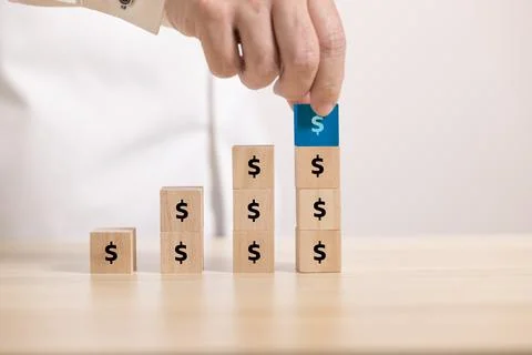 Close up hand stack Wooden block to upside bar graph with dollar icon. Concep Stock Photos