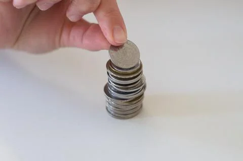 Close up hand stacking coins on white background Stock Photos