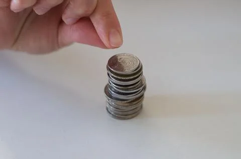 Close up hand stacking coins on white background Stock Photos