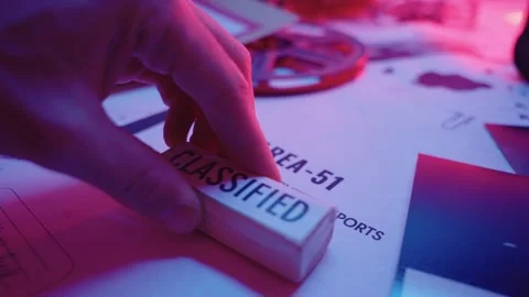 Close up on hand stamping a secret document with red ink classified stamp Stock Footage 240648645