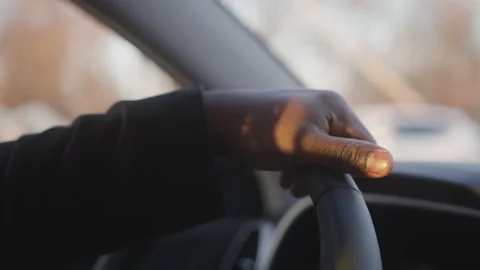 Close up of hand on the steering wheel. African american black man driving a car Stock Footage