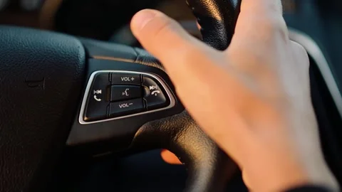 Close-up of a Hand on the Steering Wheel of a Car. Pushing a Volume Button Stock Footage 253777281