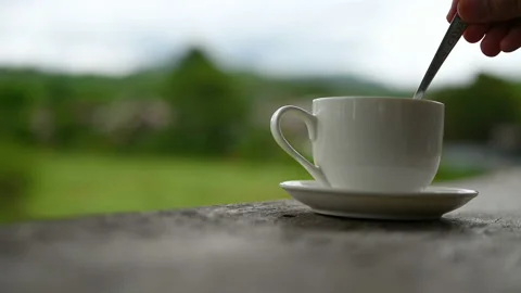 Close up hand stir the coffee or tea with cappuccino spoon on old wooden table w Stock Footage 147867812