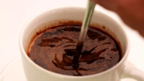 Close up hand stirring coffee in a cup with spoon. Hot Coffee Drink Concept. Stock Footage 143849187
