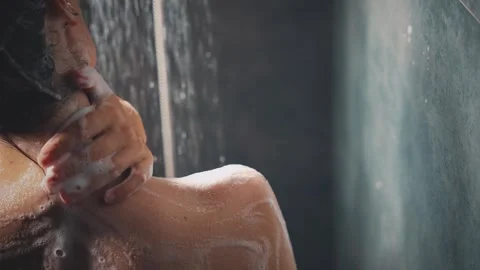 Close-up hand strokes touches cleanses shoulder skin washes away white soap foam Stock Footage 311201667