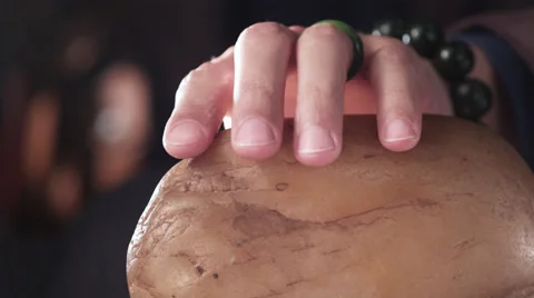 Close up of hand stroking jade stone in slow motion Stock Footage 30477501