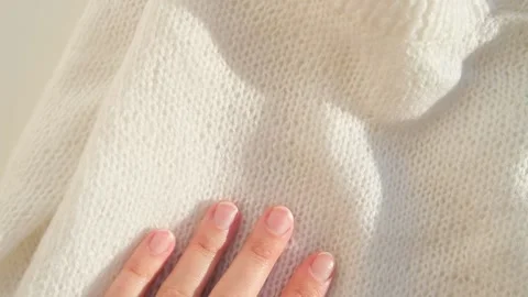 Close up hand stroking over the surface knitted soft wool cloth or warm fluffy Video stock 223672377