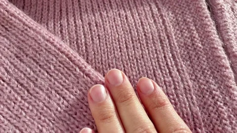 Close up hand stroking over the surface knitted soft wool cloth or warm fluffy Video stock 225451176