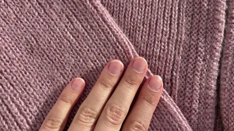 Close up hand stroking over the surface knitted soft wool cloth or warm fluffy Stock Footage 231696393