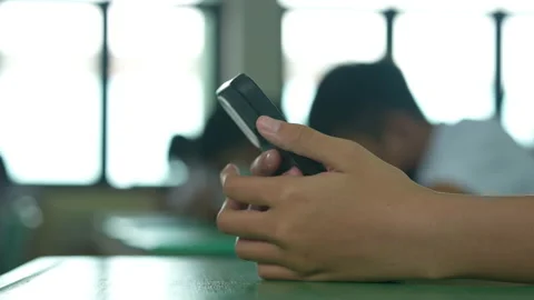 Close up hand of student holding mobile phone use learning in classroom Stockbeeldmateriaal 221612313