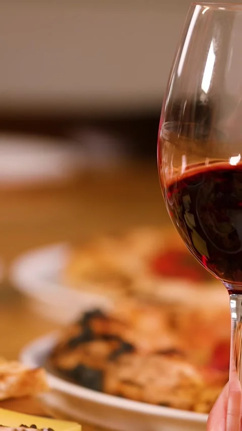 Close Up of Hand Swirling Red Wine Glass at Dinner Table Stock Footage 338427479