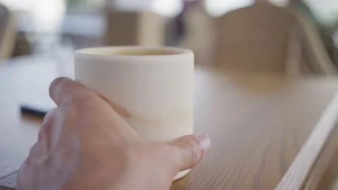 Close-up, hand takes a cup of matcha hot drink, slow motion Stock Footage 210541027