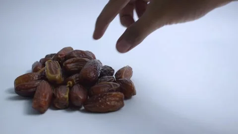 Close up hand takes dates fruit on isolated white background Stock Footage 287681878