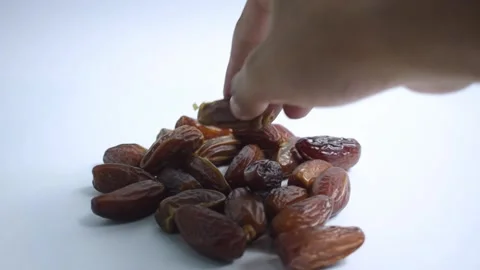 Close up hand takes dates fruit on isolated white background Stock Footage 287681899