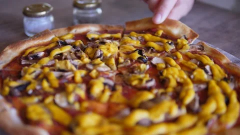 Close up of hand taking delicious slice of pizza off a wooden tray Stock Footage 146672067