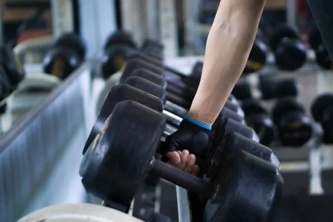 Close up hand taking heavy rusty dumbbell to exercise for strength training.  Stock Photos