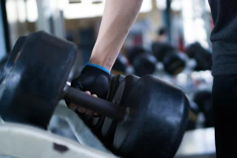 Close up hand taking heavy rusty dumbbell to exercise for strength training.  Stock Photos
