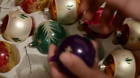 Close up of hand taking out shiny aged Christmas speheres from box Stock Footage 70332998