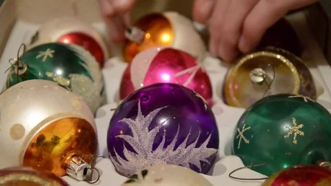 Close up of hand taking out shiny aged Christmas speheres from box Stock Footage 70333582