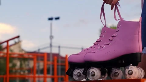 Close-up hand taking roller skates in a skate park, outdoor training, ice skatin Stock Footage 258344401
