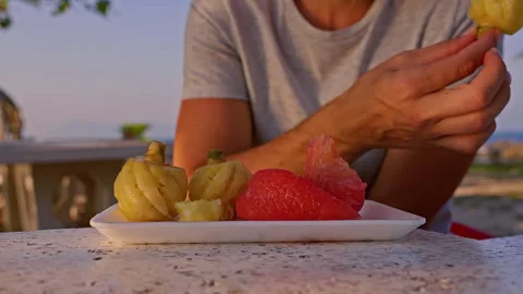 Close Up of Hand Taking Tropical Fruit from Plate with Pomelo and Pineapple at S Stock Footage 332304081