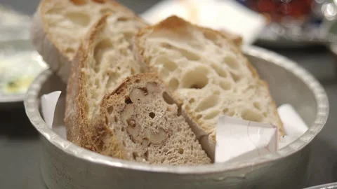 Close up of hand taking yellow bread slice from metal bowl of assorted brea.. 스톡 동영상 332882662
