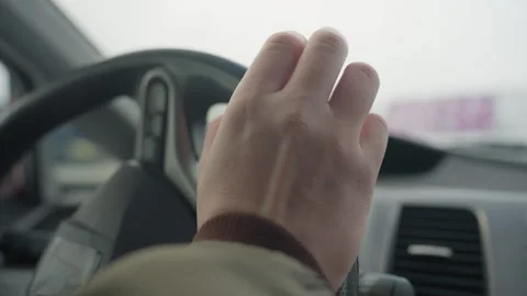 Close up hand tapping steering wheel inside parked car on winter day Vidéo 310179681