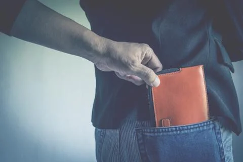 Close-up of a the hand of thief stealing the wallet to a woman. Thief stealin Stock Photos