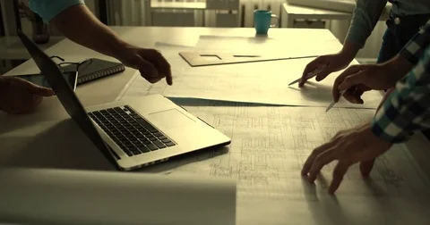 Close-up of the hand of three designers working on blueprints Stock Footage 82236848