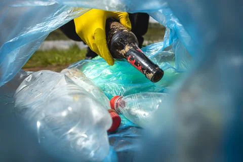 Close-up of a hand throwing garbage into a plastic bag. View from inside the bag Stock Photos