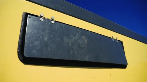 Close-up of a hand throwing a plastic bottle into a yellow recycling bin on a Stock Footage 336724444