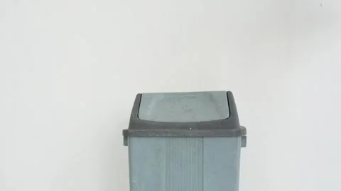Close-up of a hand throwing a used bottle into a trash can. Stock Footage 337393321